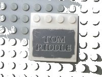 LEGO part Tile, Modified 4 x 4 with Studs on Edge with 'TOM RIDDLE' on Dark Bluish Gray Background Pattern (Sticker) - Set 4766 6179pb005