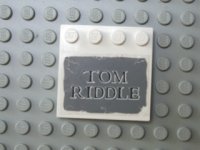 LEGO part Tile, Modified 4 x 4 with Studs on Edge with 'TOM RIDDLE' on Dark Bluish Gray Background Pattern (Sticker) - Set 4766 6179pb005