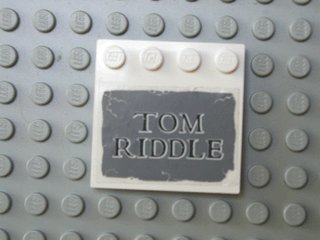 LEGO part Tile, Modified 4 x 4 with Studs on Edge with 'TOM RIDDLE' on Dark Bluish Gray Background Pattern (Sticker) - Set 4766 (6179pb005)