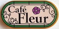 LEGO part Tile, Round 2 x 4 Oval with Black 'Café Fleur' (Cafe), Filigree and Dark Pink Flower on Light Nougat Background with Bright Green Border Pattern 66857pb089