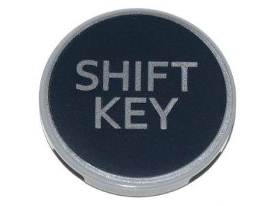 LEGO part Tile, Round 3 x 3 with Silver 'SHIFT KEY' on Black Background Pattern (67095pb009)